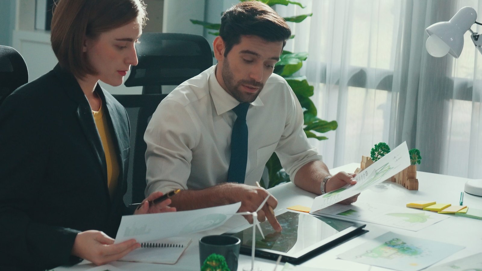 Professional business man presenting sustainable idea to manager by using tablet display ESG environmental social governance. Smart manager working together planning to use clean energy. Alimentation.