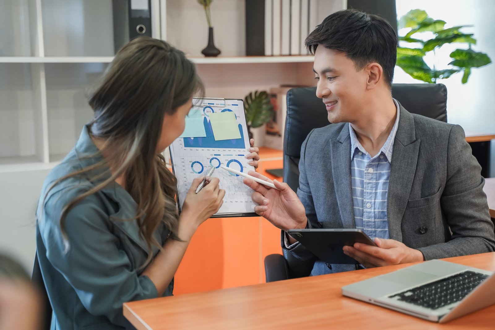 Happy businessman and businesswoman talk working team brainstorming idea on laptop and notebook job meeting communication plan project technology marketing strategy report