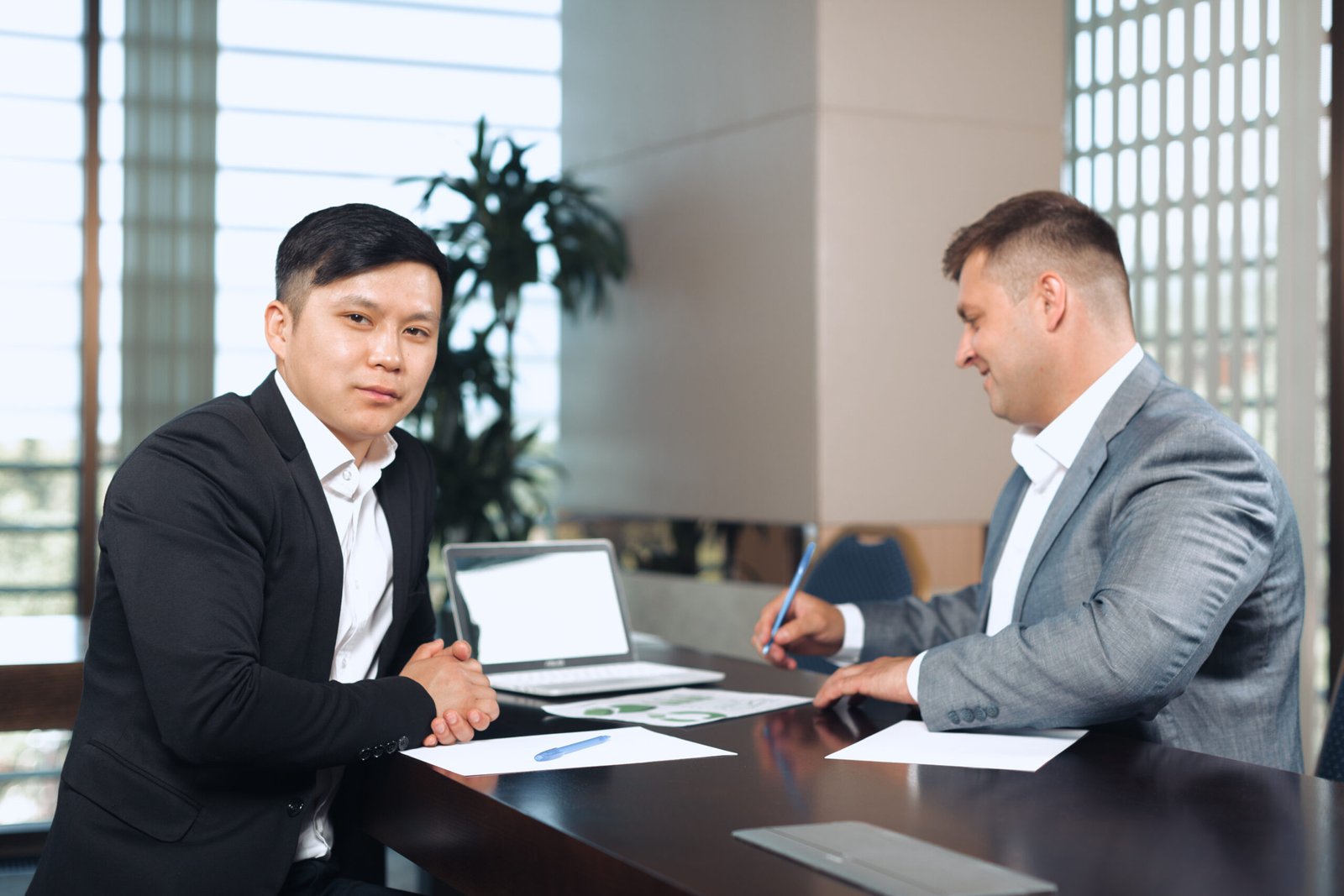 Portrait of two business partners sitting at a table together and working.