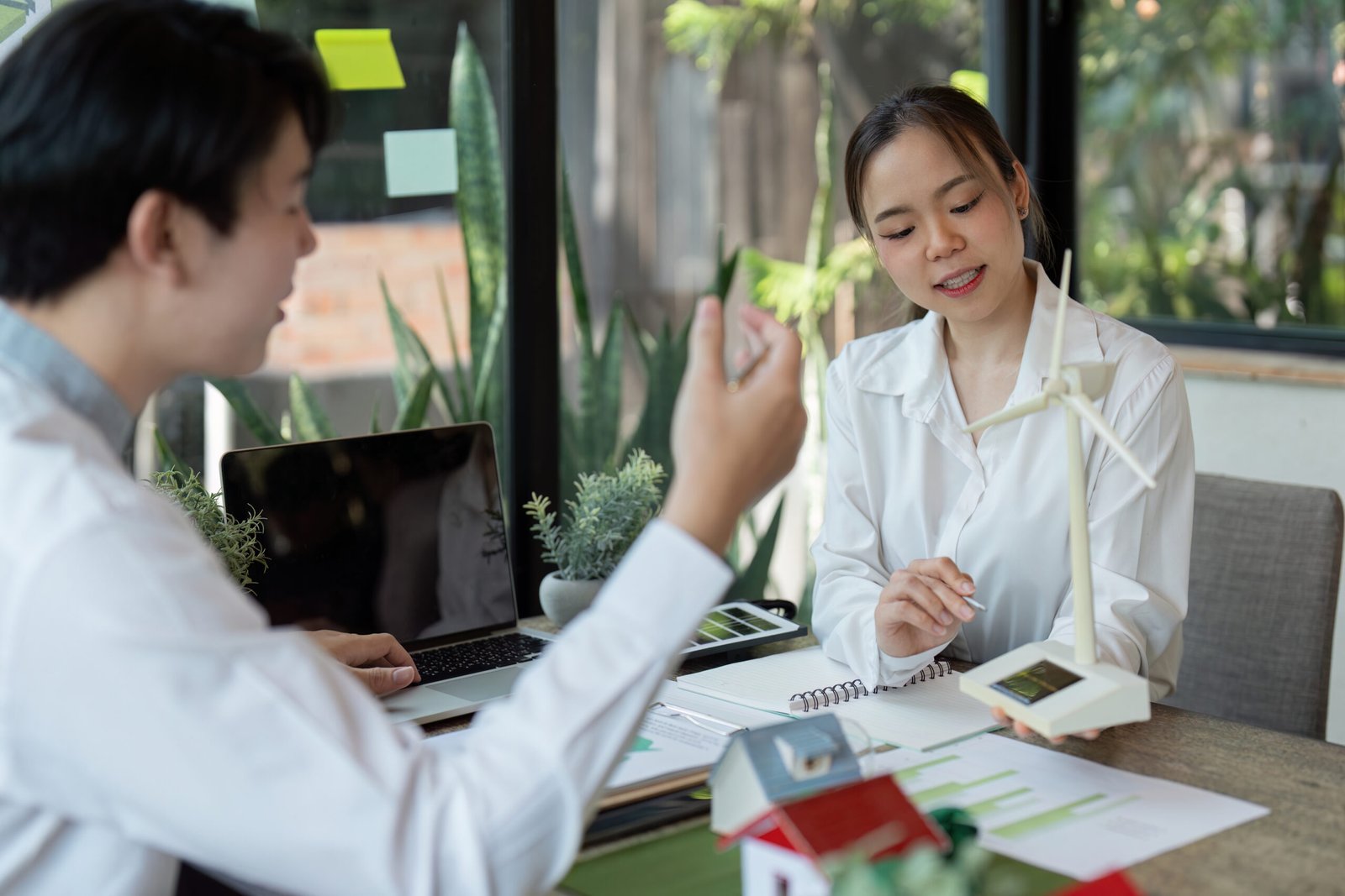 Professionals engage in a brainstorming session about renewable energy models, emphasizing collaboration and innovative sustainable practices.