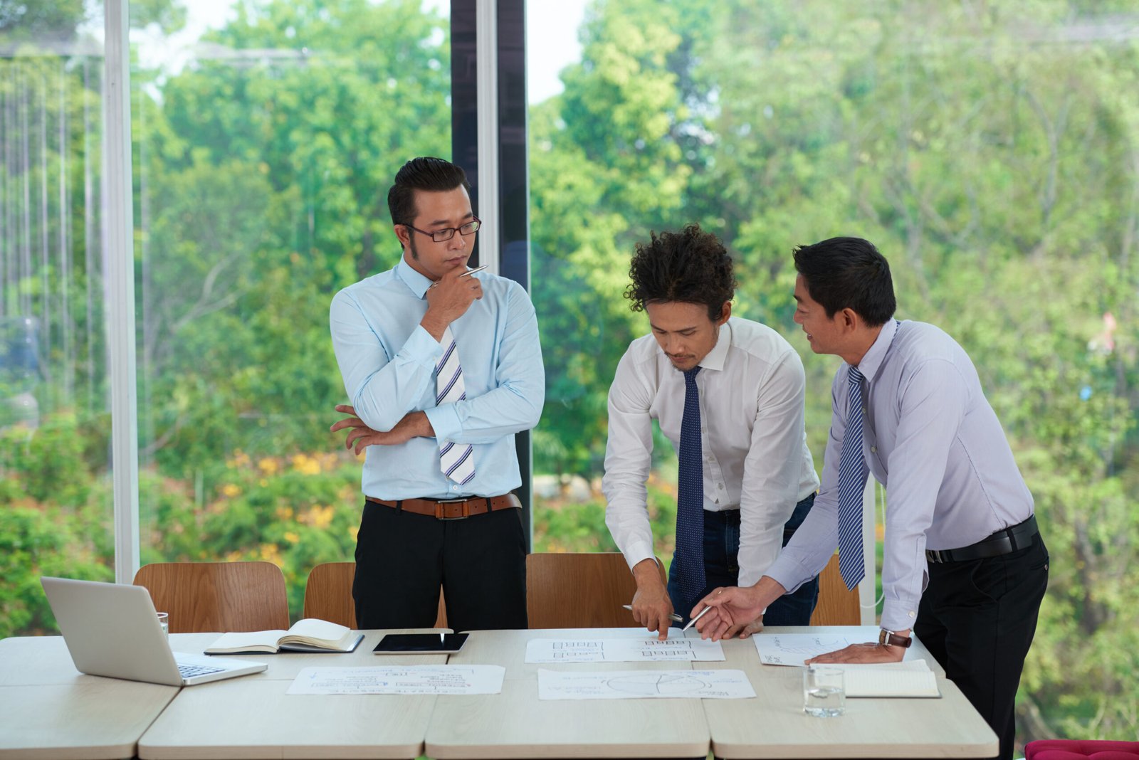 Group of colleagues working with charts and diagrams at meeting