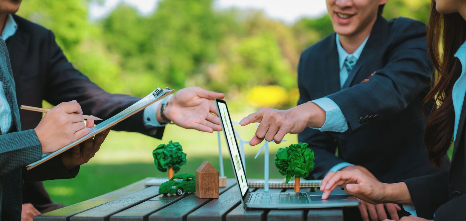 Group of asian business people presenting environmentally friendly development plan and sustainable technology project for greener future, establishing outdoor eco business office at natural park.Gyre